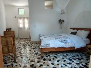 a bedroom with a bed on a hexagonal floor at Le jardin de Adja in Ngaparou