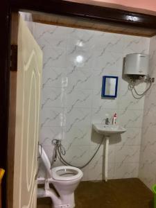 a bathroom with a toilet and a sink at Payun Homestay in Mirik