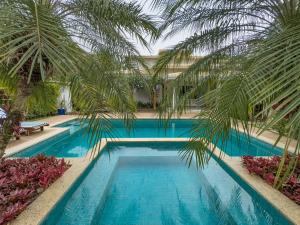 a swimming pool with palm trees in a resort at La Salamandre Paraty in Paraty