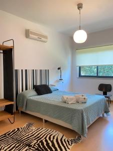 una camera da letto con un letto con due asciugamani sopra di Villa 4 Rooms, Swiming Pool Pink a Palmela