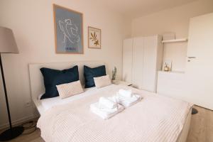 a bedroom with a large white bed with blue pillows at Loomená Apartments - Free Garage in Košice
