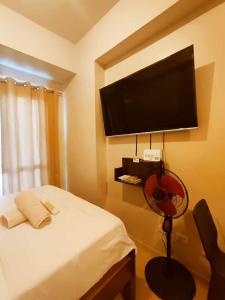 a bedroom with a bed with a fan and a flat screen tv at 1517 double in Iloilo City