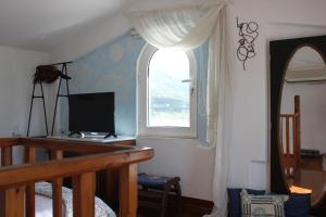 a room with a window and a desk with a television at Olive Tree House II in Dhermatiánika