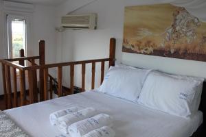 1 cama con 3 almohadas y una pintura en la pared en Olive Tree House II, en Dhermatiánika