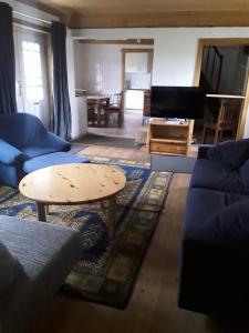 a living room with a blue couch and a table at Ferienhaus Oppeln 21 in Wingst