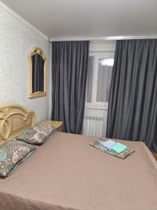 een slaapkamer met een bed met twee kussens erop bij квартира in Balqash