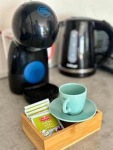 a cup and saucer on a wooden tray next to a coffee maker at Cozy Apartment near City Center in Skopje +6 photos