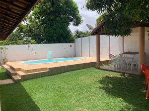 una piscina en un patio trasero con mesa y sillas en Large house with pool, barbecue and garden, en Camaçari 46 fotos más