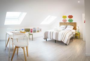 a bedroom with a bed and a desk and a table at L'Audacieux De Longueville in Saint-Quentin