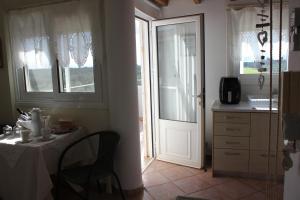 comedor con mesa y cocina con puerta en Olive Tree House II, en Dhermatiánika 35 fotos más