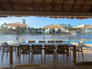 a table with chairs and umbrellas in front of a pool at Spectacular View Balcony 3 Pool's Gym and near the Beach in Conchal