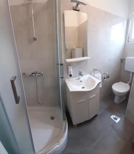 Un baño con ducha, lavabo e inodoro. en Lorena with sea view, en Rovinj 28 fotos más