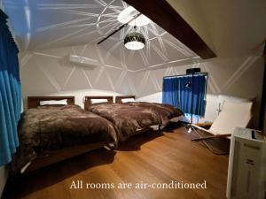 two beds in a room with a ceiling at 倉敷ながや Kurashiki Nagaya 美観地区徒歩4分 一棟貸切 無料駐車場あり 最大9名 in Kurashiki