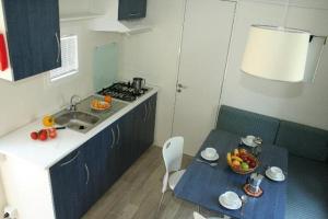 a kitchen with a sink and a table with a bowl of fruit at Camping Golden Sunset in Alissos