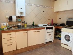 a kitchen with a stove and a washing machine at Casa Escalera Caracol in Buenos Aires