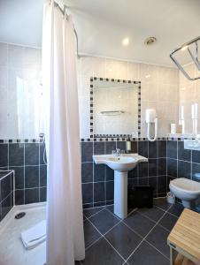 a bathroom with a shower and a sink and a toilet at H33 Hôtel in Nice
