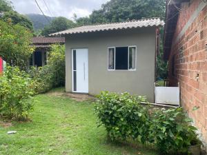a small house with a white door in a yard at Chalé do meio in Paraty
