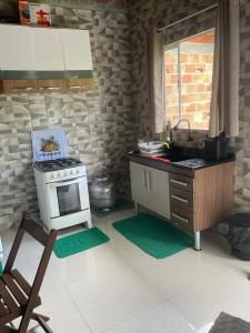 a kitchen with a stove and a sink in it at Chalé do meio in Paraty