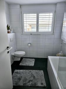 ein Bad mit einem WC, einer Badewanne und einem Fenster in der Unterkunft Looking for some time off in Höchst