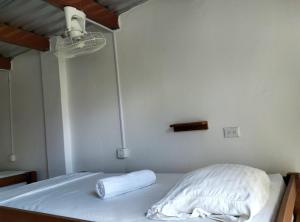 a bed with a white blanket on it in a room at Nómadas Hostel in Moyogalpa +2 photos