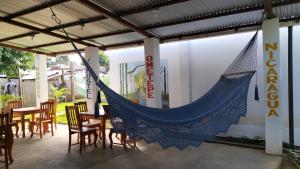 a hammock in a restaurant with tables and chairs at Nómadas Hostel in Moyogalpa