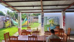 a man sitting at a table in a restaurant at Nómadas Hostel in Moyogalpa