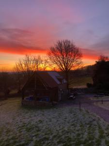 a barn in a field with a sunset in the background at The Stable in Sourdeval