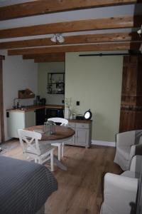 a living room with a table and a kitchen at B&B Peelgoed in Kronenberg