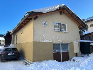 ein Haus mit einem davor geparkten Auto in der Unterkunft Ferienwohnung Edelweiss, in Splügen