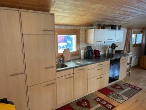 eine Küche mit Holzschränken und einer Spüle in der Unterkunft Ferienwohnung Edelweiss, in Splügen