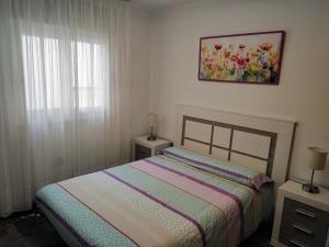 a bedroom with a bed and a painting on the wall at LAS PALMERAS in Almuñécar +46 photos