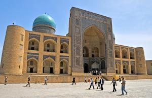 a group of people walking in front of a building at Olimxon Guest House in Bukhara