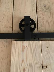 a black holder on a wooden floor with a dog footprint at glamping met landelijk uitzicht in Spanga +19 photos