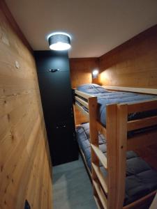 a room with two bunk beds and a light at Residence La Vanoise - Appartement chaleureux ski aux pieds in Val Thorens