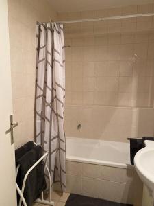 a bathroom with a bath tub and a sink at Orlyvo appartement Middelkerke in Middelkerke