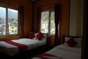 博卡拉Hotel old durbar的有两张床的房间有两扇窗户 更多11张照片