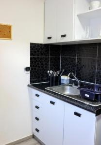 a kitchen with white cabinets and a sink at Tranquila casa in Mexico City