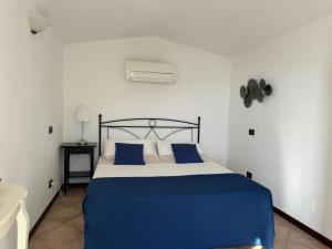 ein Schlafzimmer mit einem Bett mit blau-weißer Bettwäsche in der Unterkunft Cottage con vista mozzafiato sul mare - Monterosso al mare in Monterosso al Mare