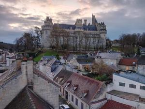 a large castle on top of a city with roofs at Urban Nest in Beauvais