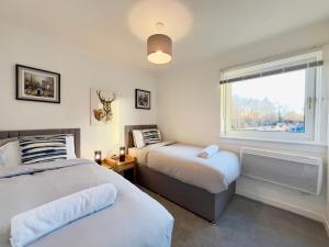 due letti in una stanza con finestra di Chic & Cozy 2-Bed Flat in Glasgow - Free Parking a Glasgow