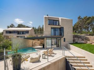 a house with a swimming pool in front of it at Unique 4-Bedroom Villa SemperVivum with pool in Sutivan in Sutivan