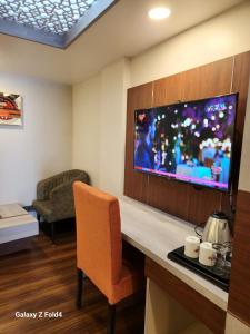 a hotel room with a tv and a chair at Luxury stay at Hotel Broadway Boutique Mall Road Chowrasta Near Mahakal Temple in Darjeeling +80 photos
