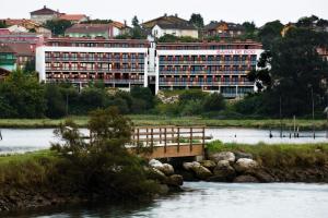 a bridge over a river in front of a building at Apartamentos Bahía de Boó in Guarnizo