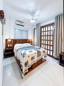 a bedroom with a bed with a blanket on it at Cond Vista Hermosa - Casas 2 quartos by Pipa Centro in Pipa