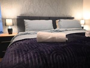 a bed with a rolled up towel on top of it at Central located apartment with parking in Cheltenham