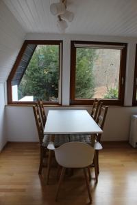 a table and chairs in a room with two windows at Naturzauber in Sonnenbühl