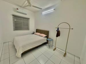 a bedroom with a bed in a white room at Urban Eats Stay in Ipoh