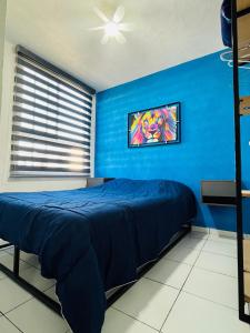 a blue bedroom with a bed and a blue wall at Departamento a 10 minutos del aeropuerto in El Castillo +8 photos