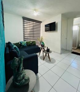 a living room with a blue couch and a table at Departamento a 10 minutos del aeropuerto in El Castillo