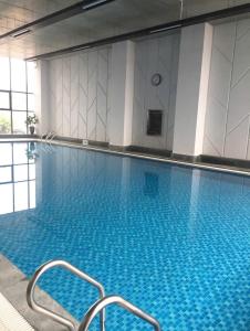 ein großes Schwimmbecken mit blauem Wasser in einem Gebäude in der Unterkunft Northern Diamond Golfstay in Hanoi